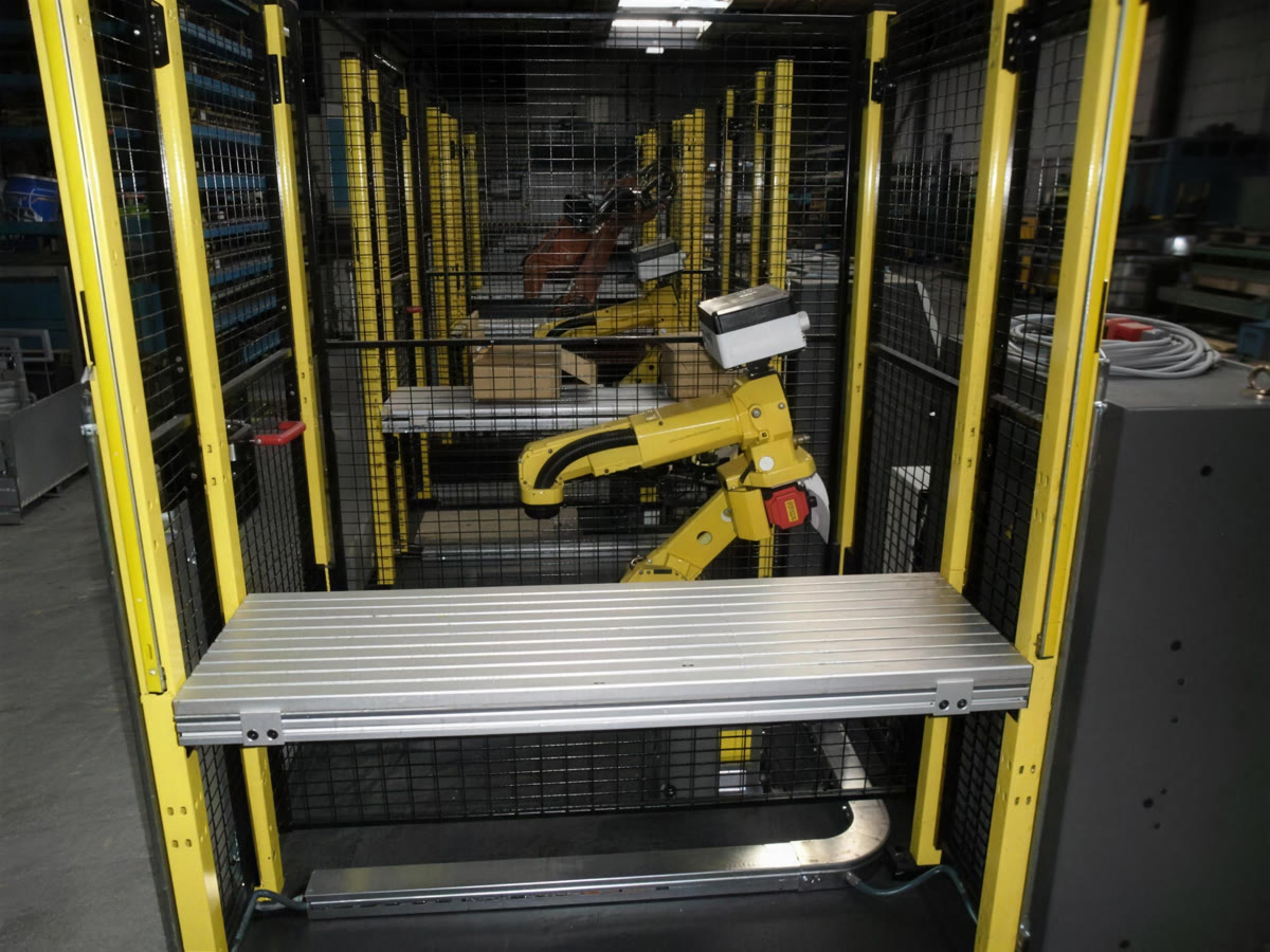 Robotcel met gele veiligheidsomheining en werktafel