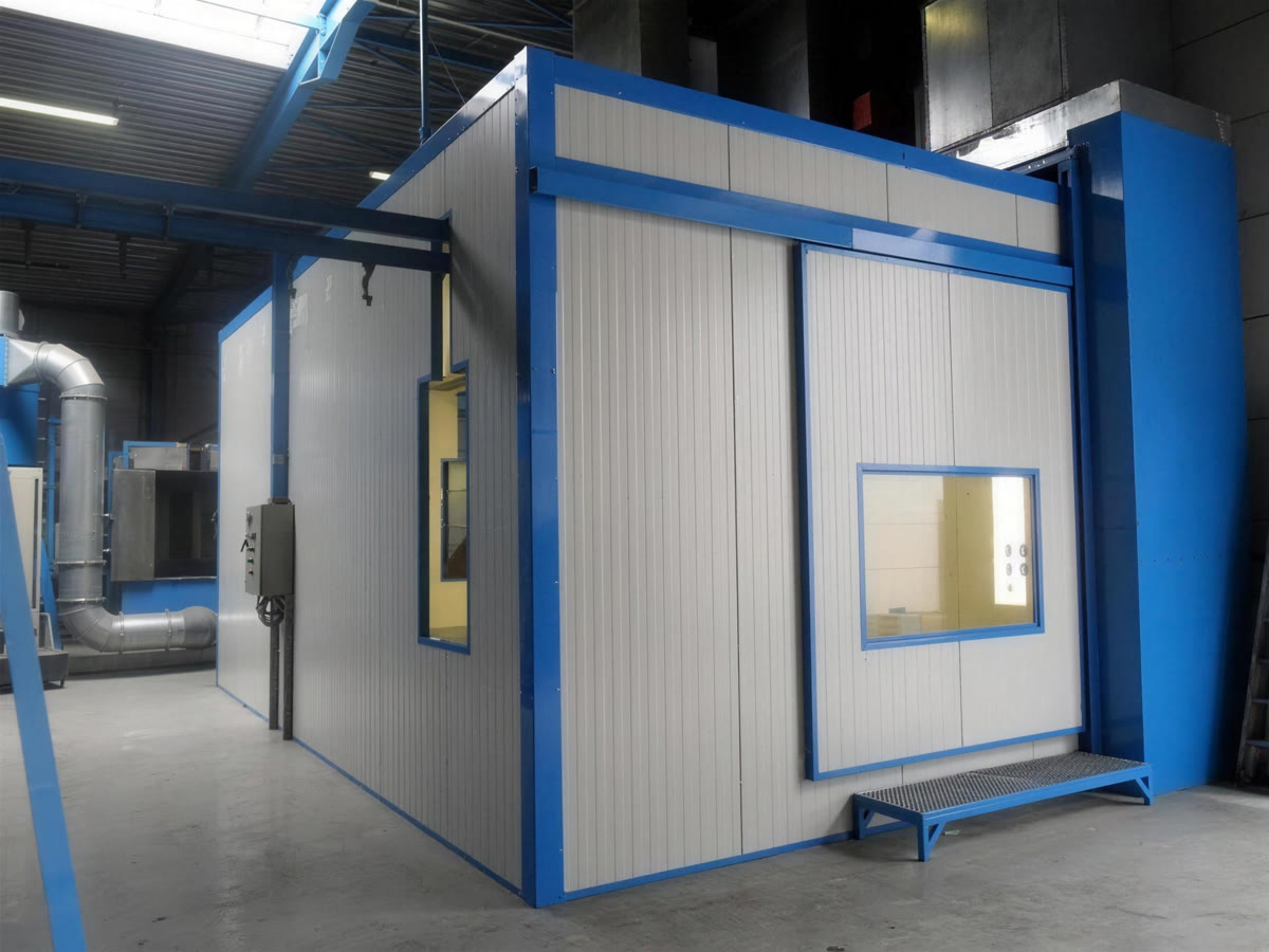 Spuitcabine met blauwe kaders in een productiehal